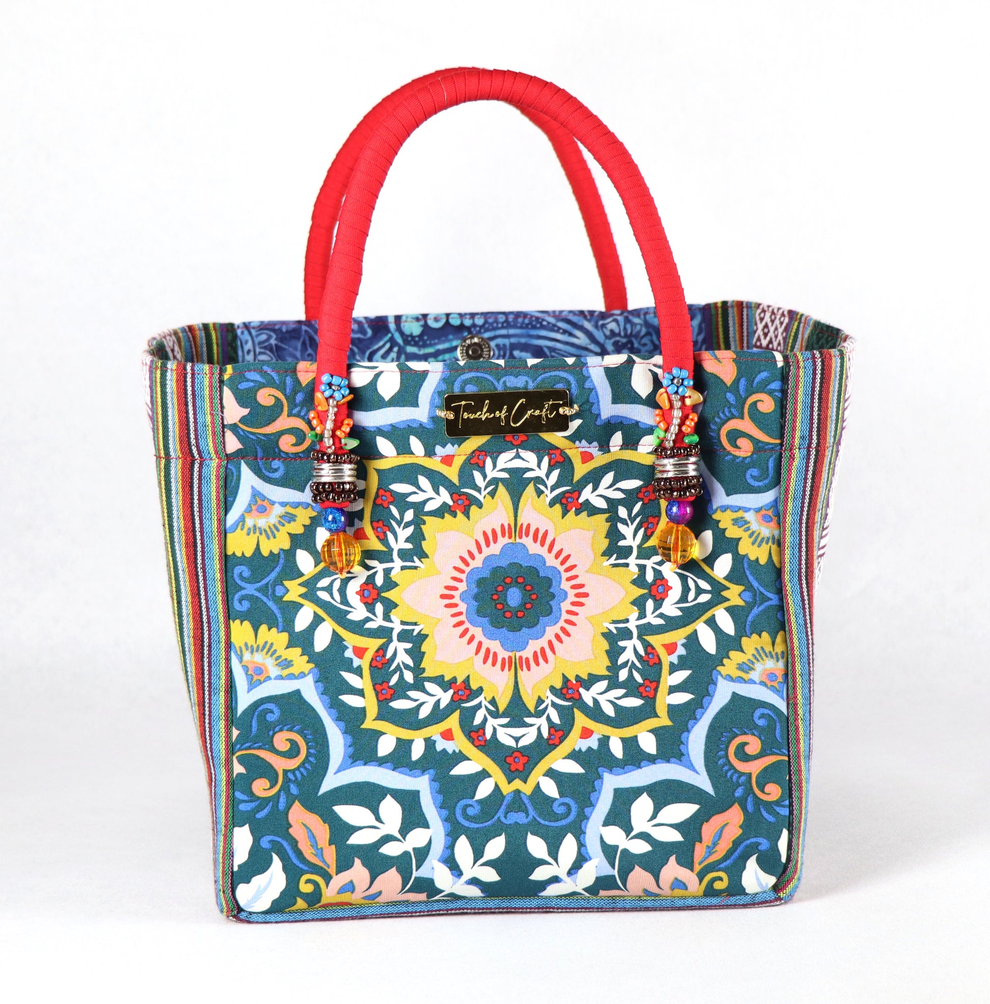 The bag comes in red handle, green Aztec pattern on the side, and a green, yellow, and blue flower pattern on the back.