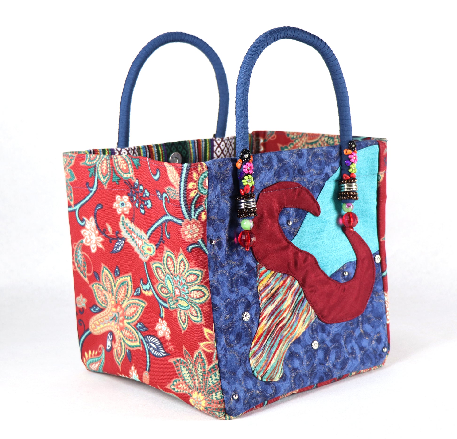 The bag comes in blue handle, red flower patterns on the side, and a green Aztec pattern on the back.