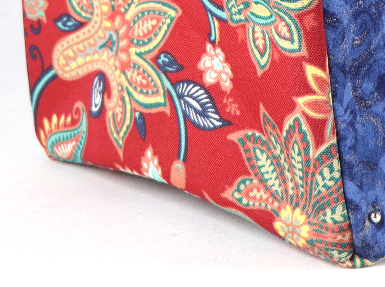 The bag comes in blue handle, red flower patterns on the side, and a green Aztec pattern on the back.