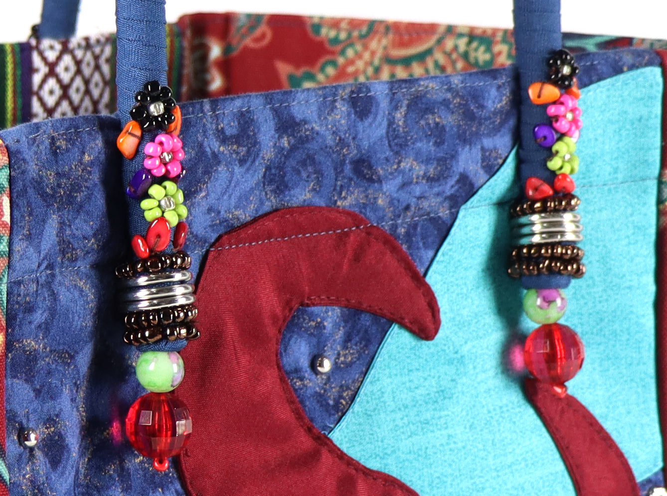 The bag comes in blue handle, red flower patterns on the side, and a green Aztec pattern on the back.