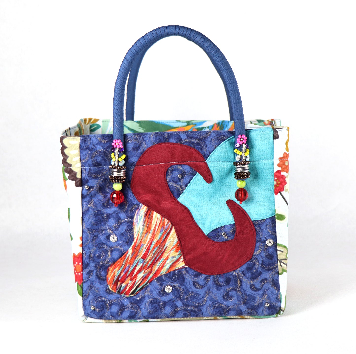 The bag comes in blue handle, yellow, orange and green flower patterns on the side, and a green leaves pattern on the back.