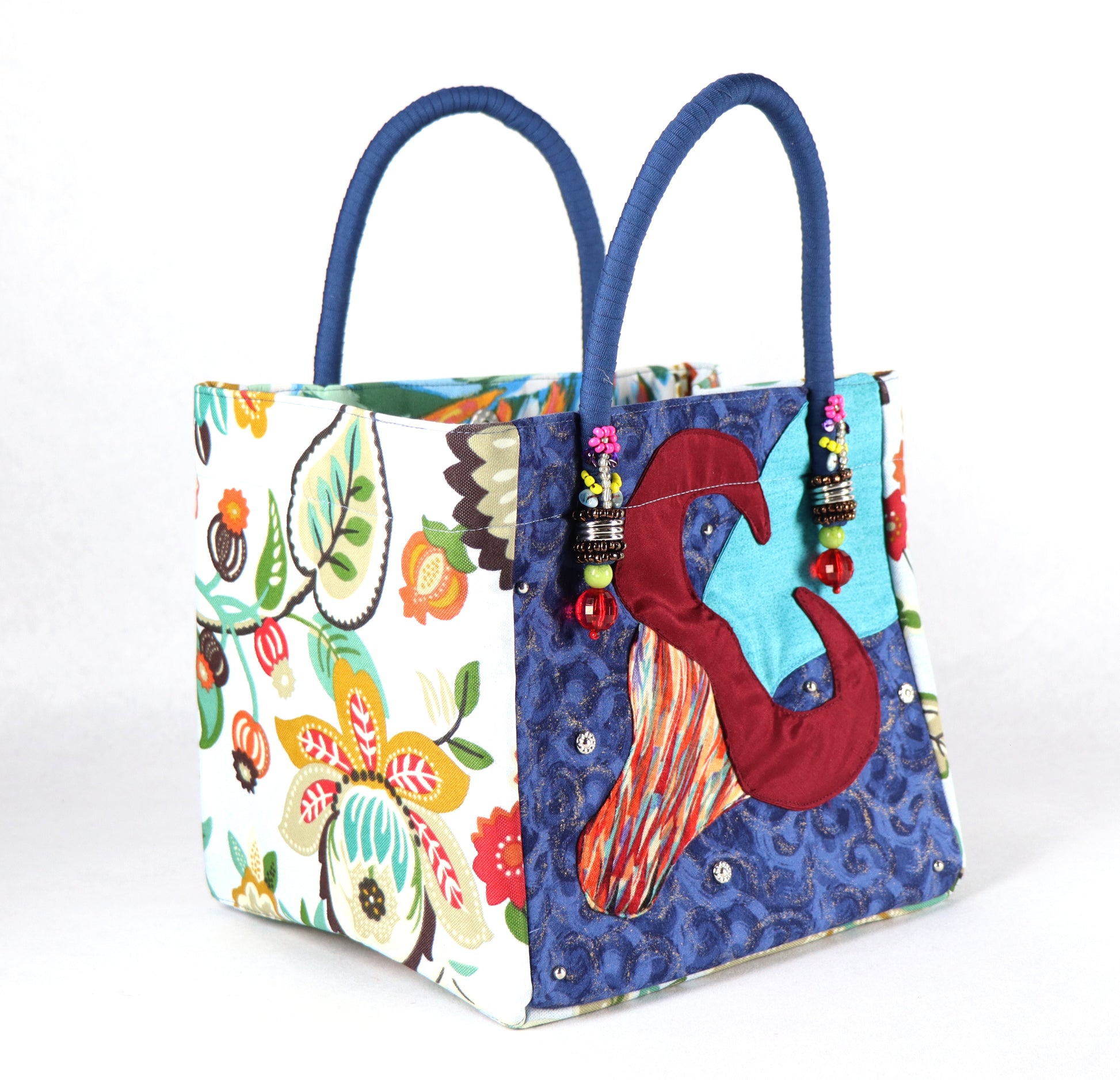 The bag comes in blue handle, yellow, orange and green flower patterns on the side, and a green leaves pattern on the back.