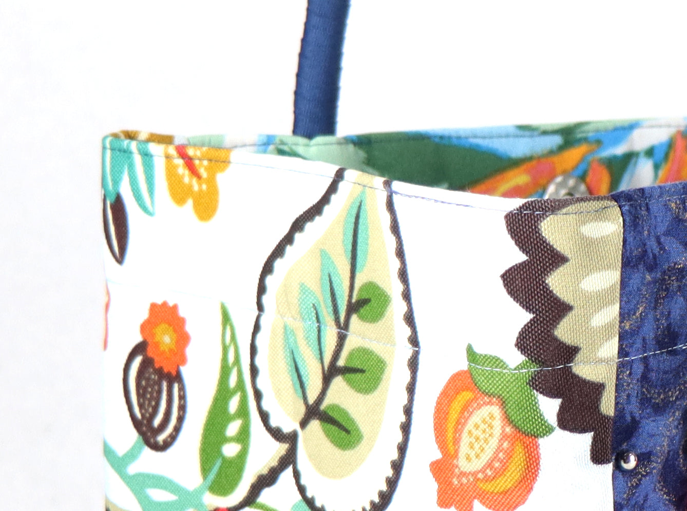 The bag comes in blue handle, yellow, orange and green flower patterns on the side, and a green leaves pattern on the back.