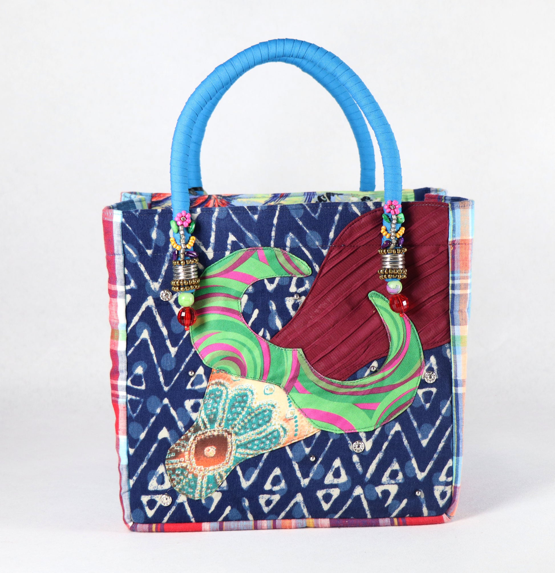 The bag comes in light blue handle, blue-red checkered on the side, and a paradise pattern on the back.