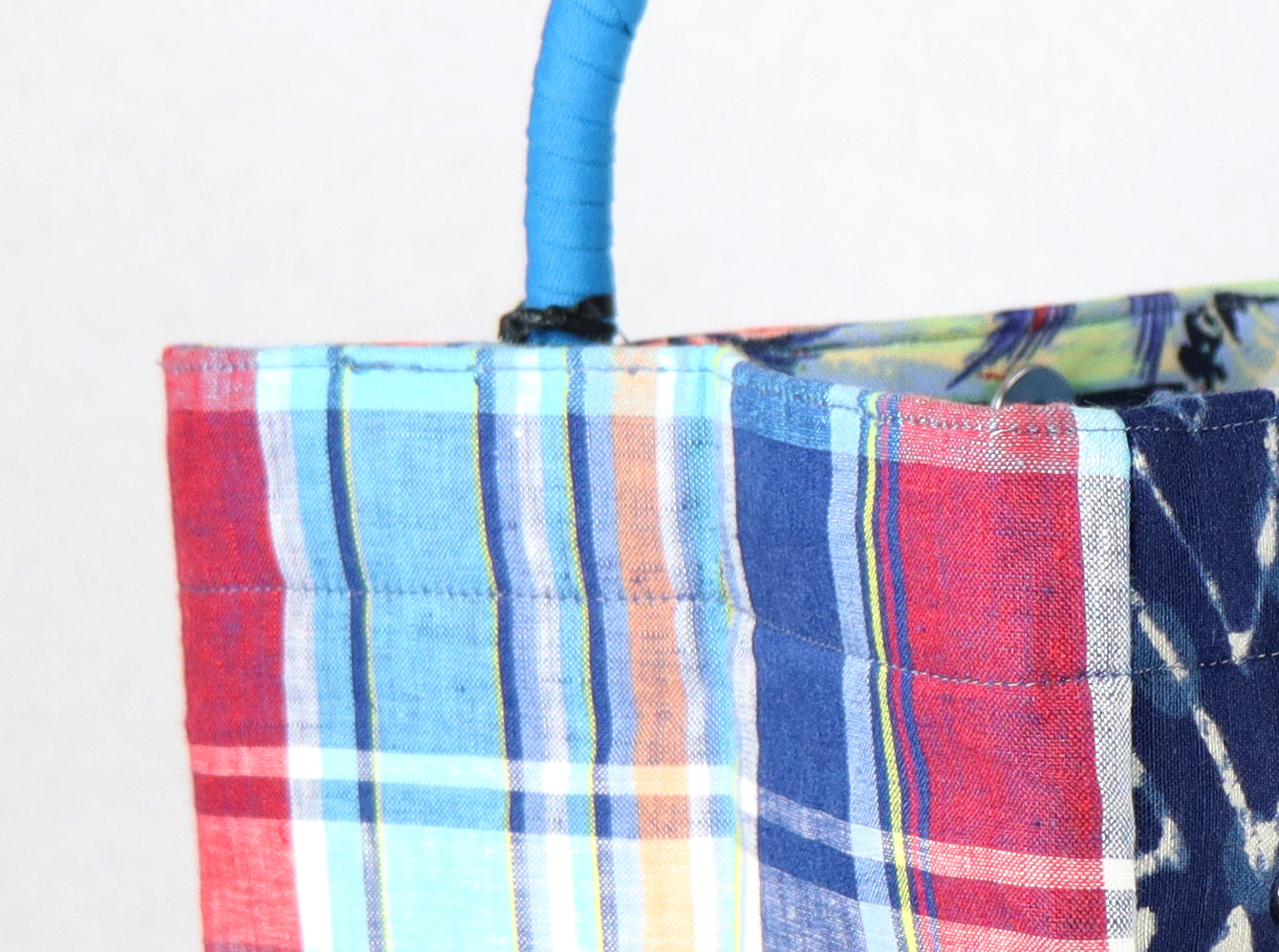 The bag comes in light blue handle, blue-red checkered on the side, and a paradise pattern on the back.